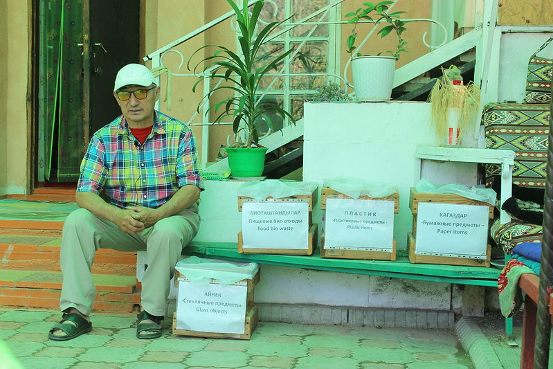 a man sitting on a bench in front of a store