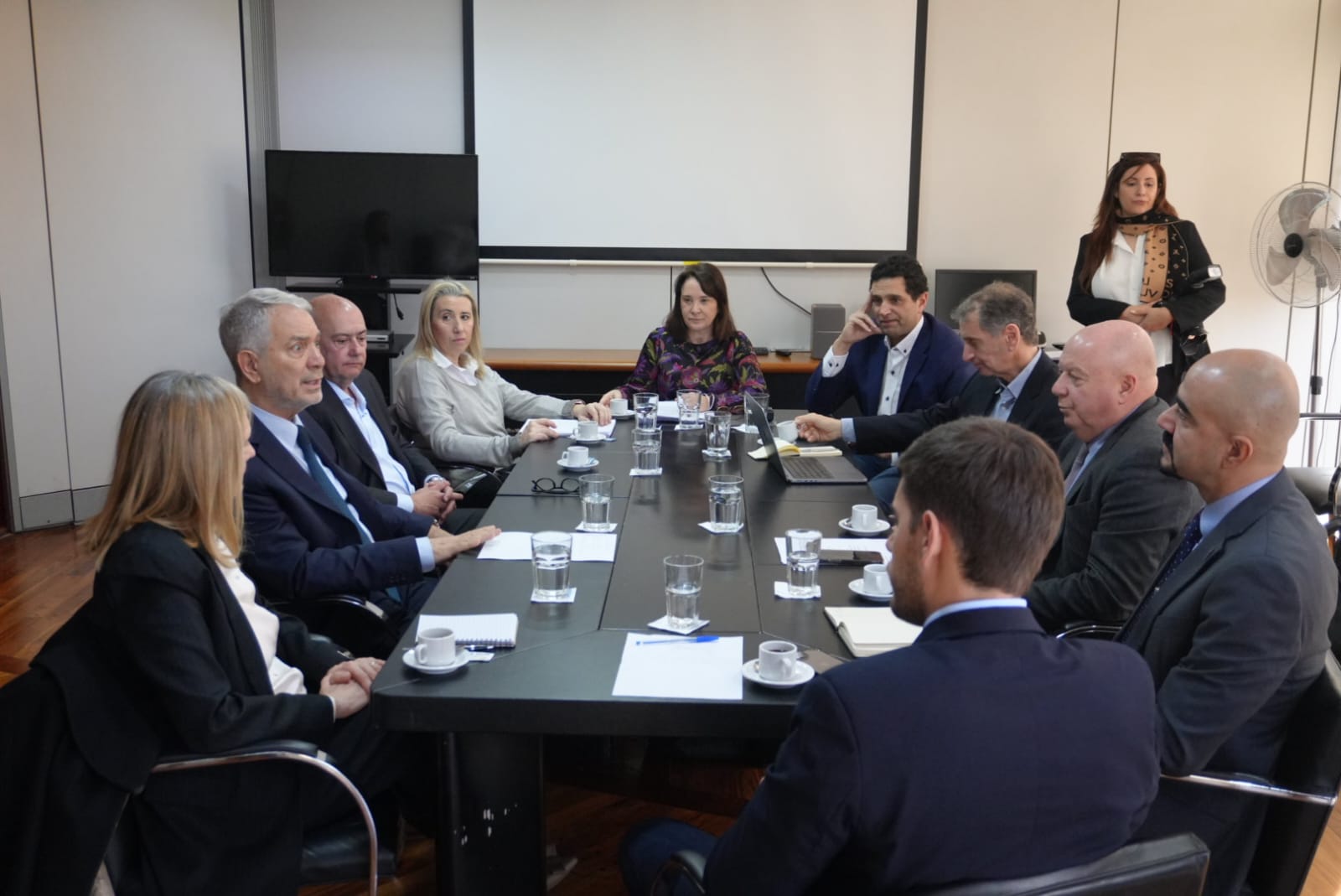 Un grupo de personas sentadas en una mesa con copas de vino