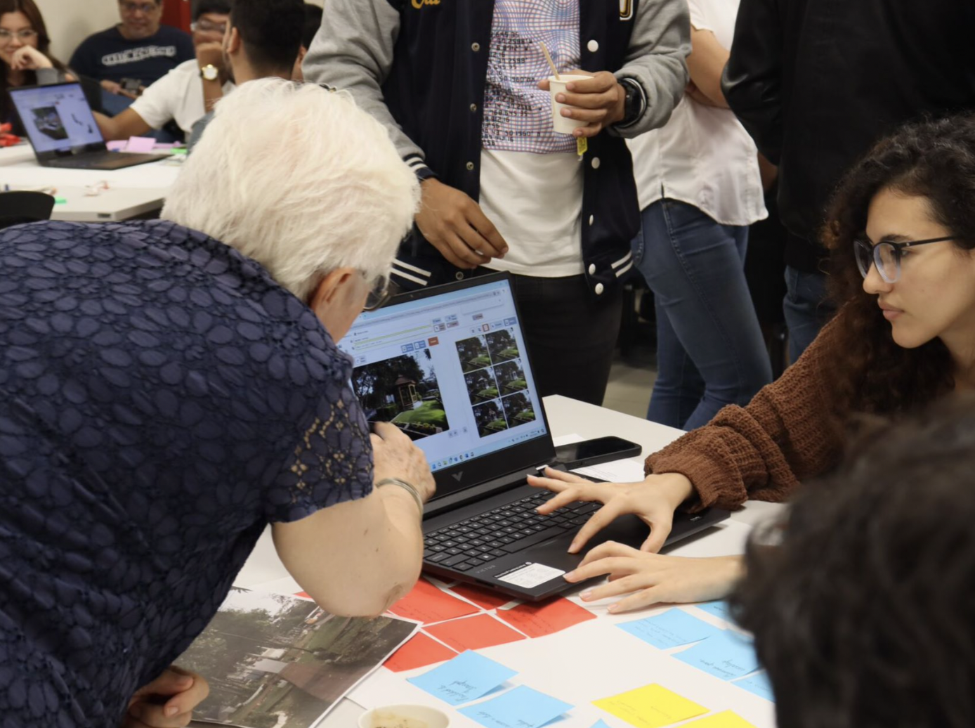 a group of people looking at a laptop