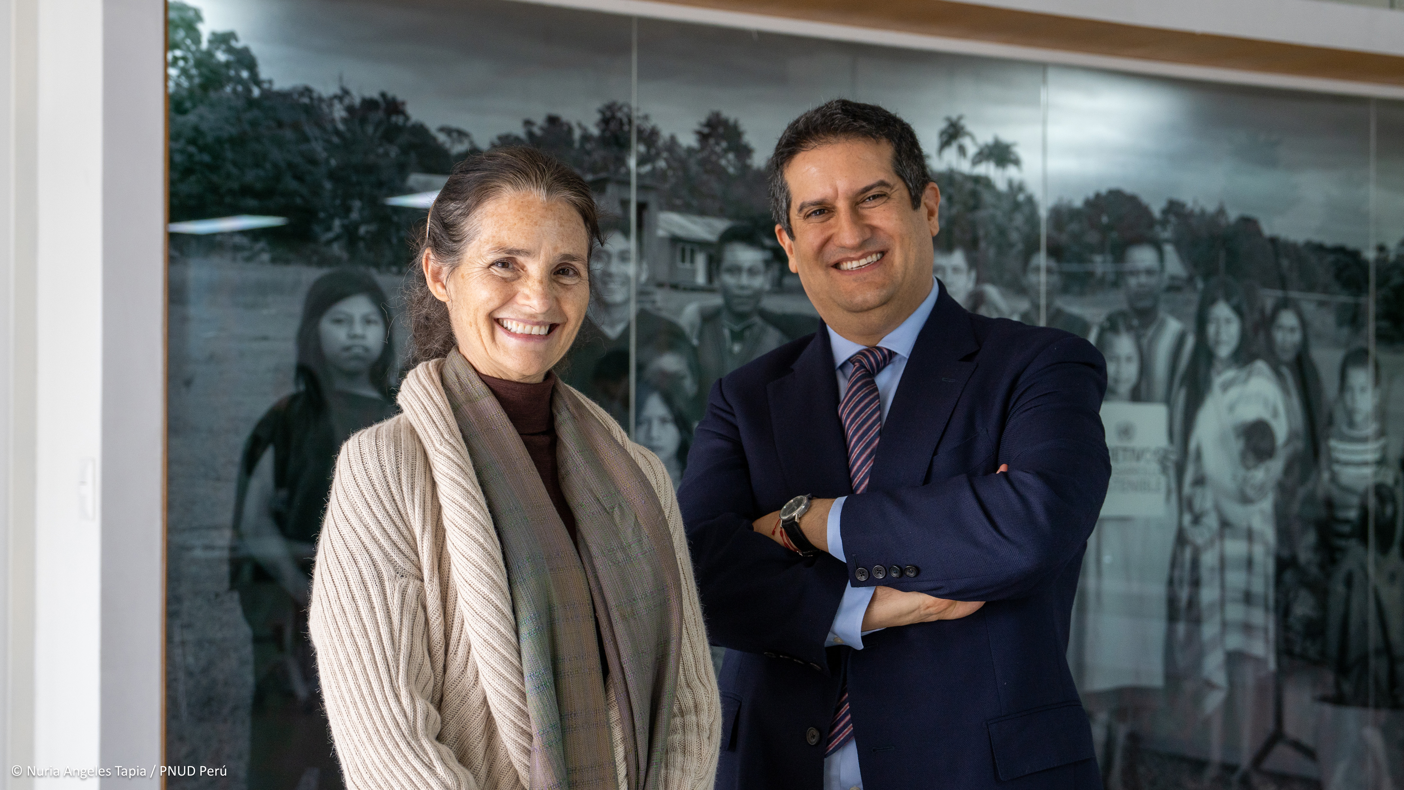 a man and a woman standing in front of a photo