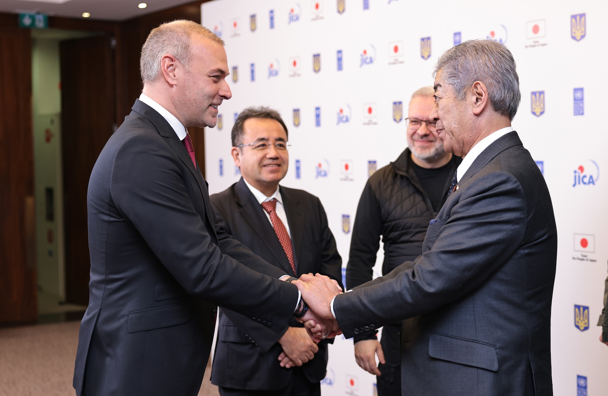 a couple of men standing next to a person in a suit and tie